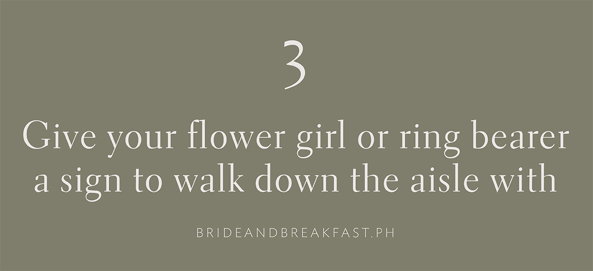 3. Give your flower girl or ring bearer a sign to walk down the aisle with